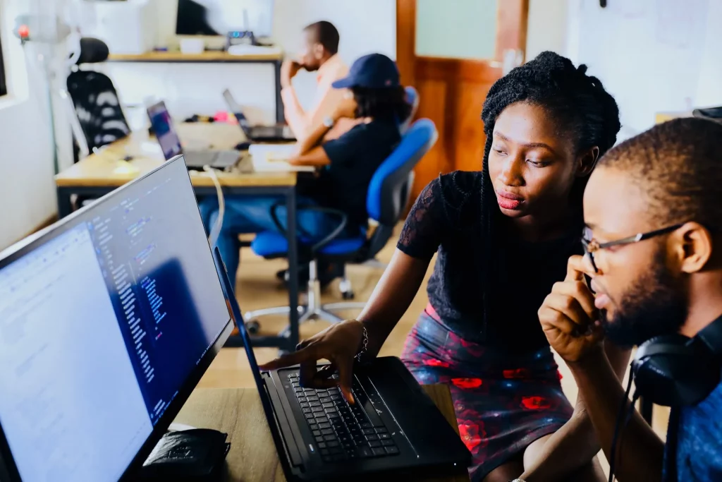 Man and woman sitting in front of monitor