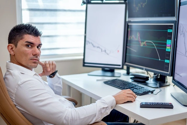 Man in White Long Sleeves Shirt Sitting in Front of a Computer